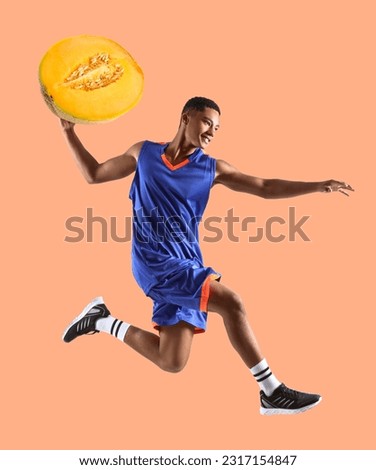 Jumping African-American basketball player with juicy melon on orange background
