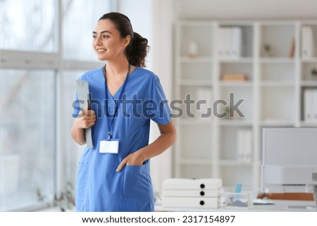 Female medical assistant with clipboard in clinic Royalty-Free Stock Photo #2317154897