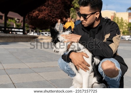 A young naughty Border Collie dog in an urban environment with his owner. Pictures of pet Border Collie dogs with their owners.