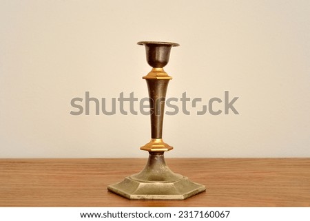Rustic candlestick on the brown wooden dresser. Vintage candle holder without candles.  Royalty-Free Stock Photo #2317160067