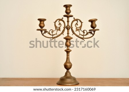 Rustic candlestick on the brown wooden dresser. Vintage candle holder without candles.  Royalty-Free Stock Photo #2317160069