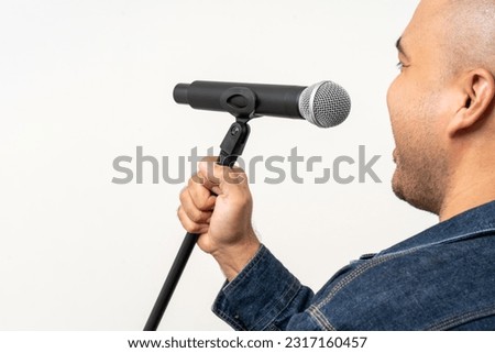 Close up male hand holding High quality dynamic microphone and singing song or speaking talking with people on isolated white background. Male testing microphone voice for interview