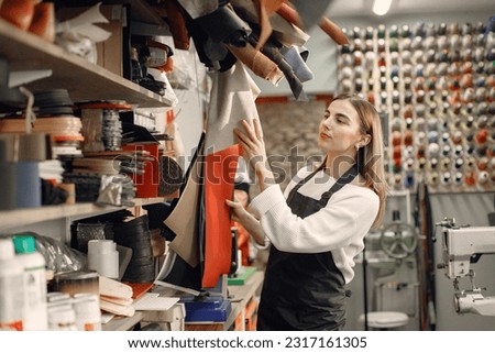 Woman tailor choosing a material leather sheet for her work Royalty-Free Stock Photo #2317161305