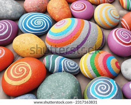 Painted round natural stones with decorated lines and patterns Royalty-Free Stock Photo #2317163831