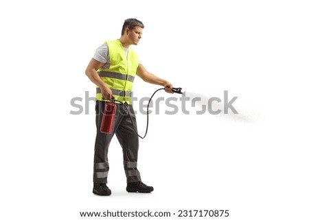 Man in a reflective safety vest using a fire extinguisher isolated on white background