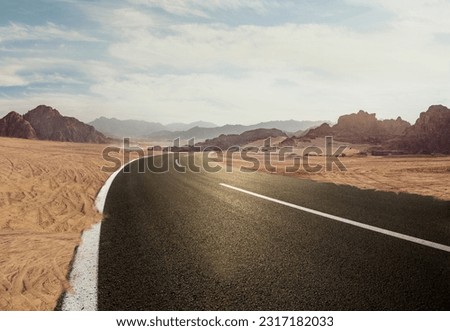 Road in the desert, Empty road. , Travel Highway through the Sahara showing the texture of asphalt sand street, mountain, and hills landscape with dust skyline on a sunny summer day in the background	
