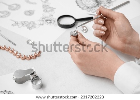 Female jeweler making ring on white table, closeup Royalty-Free Stock Photo #2317202223
