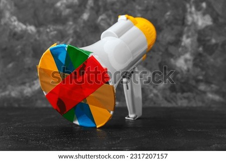 Taped megaphone on dark table. Censorship concept Royalty-Free Stock Photo #2317207157