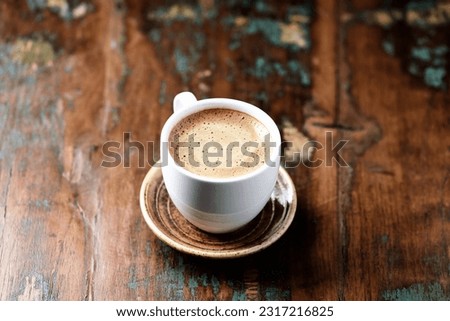 Cup of coffee on rustic wooden background. Soft focus. Close up. Copy space.                                                                                           Royalty-Free Stock Photo #2317216825