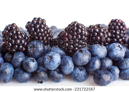 Freshly picked blueberries and blackberries isolated on white background 