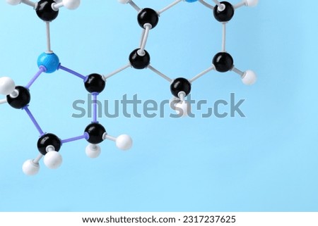 Molecule of nicotine on light blue background, closeup and space for text. Chemical model