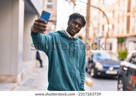 African american man smiling confident making selfie by the smartphone at street