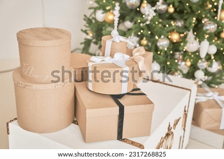 The Christmas tree is decorated with toys and garlands with gifts under it. Christmas gifts under the Christmas tree made of craft paper with space for copying. High quality photo
