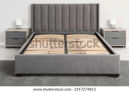 Comfortable bed with storage space for bedding under slatted base in room Royalty-Free Stock Photo #2317274813