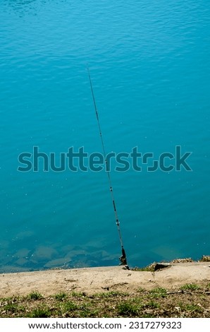 Fishing rod, spoon, hooks on a brown wooden background. fishing bait. close up. throw-line. fishing rod. Rod on the bridge. Bridge passes through the lake, river. flat lay. top view.
