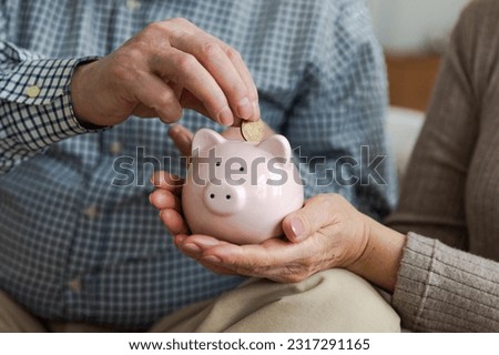 Saving money investment for future. Senior adult mature couple hands putting money coin in piggy bank. Old man woman counting saving money planning retirement budget. Saving investment banking concept Royalty-Free Stock Photo #2317291165