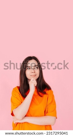 Thoughtful Woman Gazing, Hand on Chin, Contemplating an Empty Space. Isolated on Pink Background. Ideal for Concepts of Reflection, Ideas, Inspiration, and Creativity.
