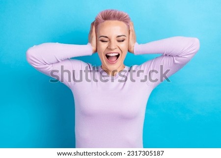 Photo of crazy dissatisfied girl with short haircut dressed pink shirt palms cover ears screaming isolated on blue color background