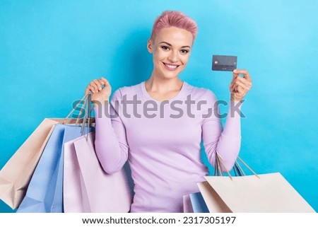 Photo of good mood girl short haircut dressed pink shirt holding bags debit card make online order isolated on blue color background