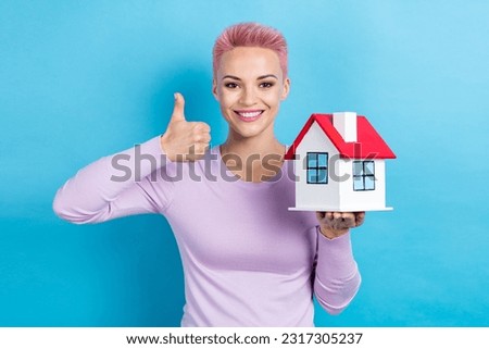 Photo of pink short hair girl thumb up feedback buy cheap apartment hold little building advertisement isolated on blue color background