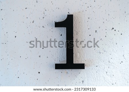 Number one 1 floor sign symbol on white concrete wall background with texture