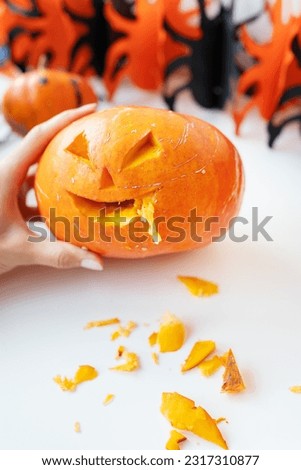 October 31. Halloween holiday. The carved face of a pumpkin on an orange and black background. Selective focus, noise.