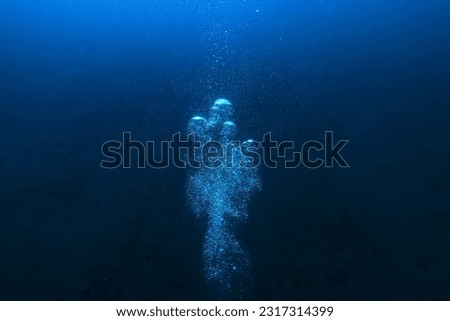 air bubbles underwater background diving in the sea Royalty-Free Stock Photo #2317314399