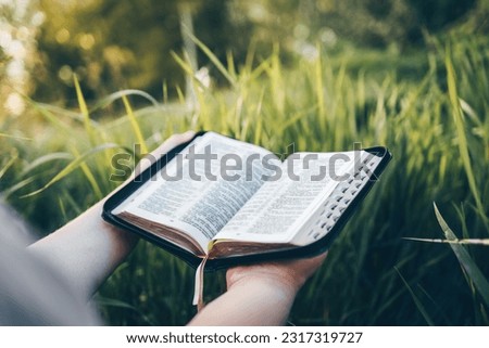 Open bible in hands close-up, concept of calmness and morning solitude. Royalty-Free Stock Photo #2317319727