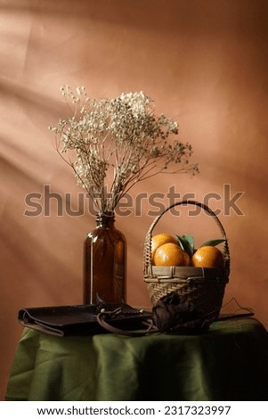 Orange fruits and baby breath dry flower on the table in dramatic Still Life photography