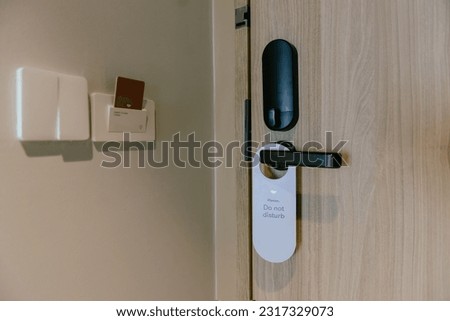 At the door of a luxury hotel hangs a Do Not Disturb sign.