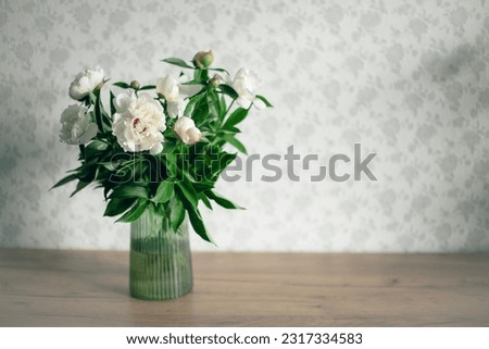Fresh white fragrant peonies on the background of a home interior