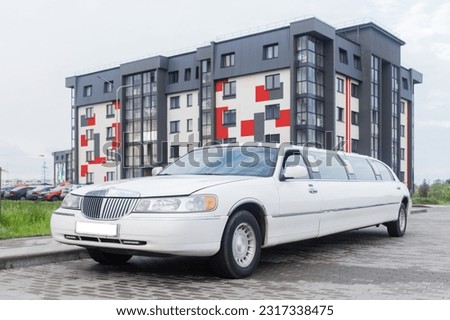 White limousine luxury long car for celebrations and celebrations against the backdrop of a modern city building. Royalty-Free Stock Photo #2317338475