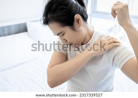 Asian middle aged woman suffering from frozen shoulder,pain and stiffness,unable to move,difficulty lifting his arm,female people with calcific tendonitis,shoulder injuries,health care,medical concept Royalty-Free Stock Photo #2317339527