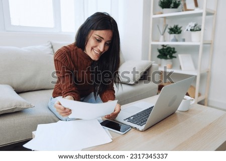 A woman does financial calculations and document analysis at home with a laptop, a freelancer works 