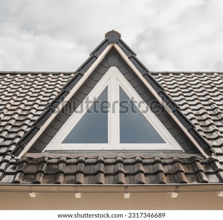 Modern house roof with dormer and triangular window made of white PVC Royalty-Free Stock Photo #2317346689