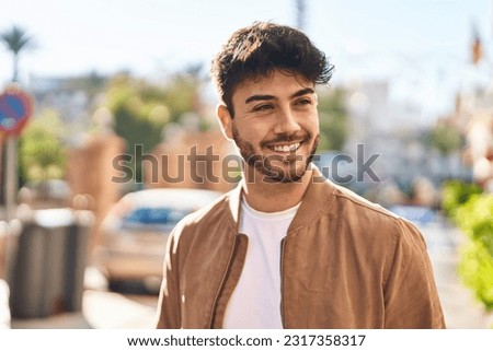 Young hispanic man smiling confident looking to the side at street Royalty-Free Stock Photo #2317358317