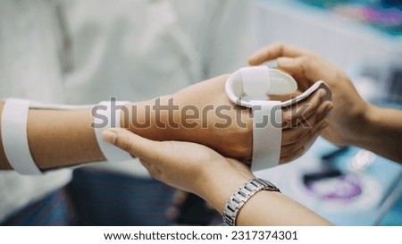 Therapist making asissistive device for immobilize patient hand. Splint service for hand injury rehabilitation of occupational therapy clinic. Royalty-Free Stock Photo #2317374301