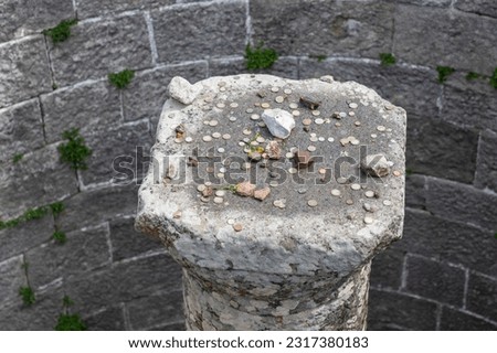 A picture of coins thrown by tourists on top of a column at the Pergamon Ancient City.
