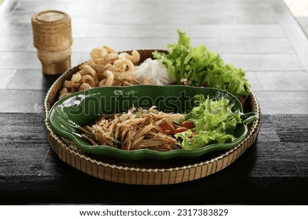 Som tum Papaya salad with pork crackling, eggs, vegetable, and sticky rice Royalty-Free Stock Photo #2317383829
