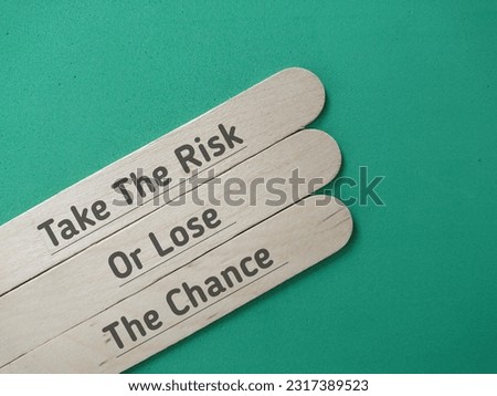 Motivation quote text Take The Risk Or Lose The Chance at ice cream sticks on green background. 
