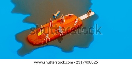 closeup of some miniature people in swimsuit on a melting orange popsicle, on a blue background, in a panoramic format to use as web banner Royalty-Free Stock Photo #2317408825