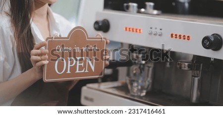 Welcome. Open. barista, waitress woman turning open sign board on glass door in modern cafe coffee shop ready to service, cafe restaurant, retail store, small business owner, food and drink concept