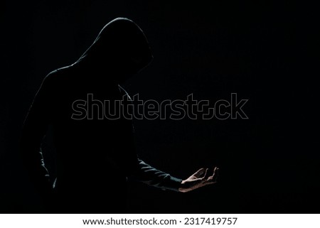 The silhouette of unknown person with backlight on the dark background Royalty-Free Stock Photo #2317419757