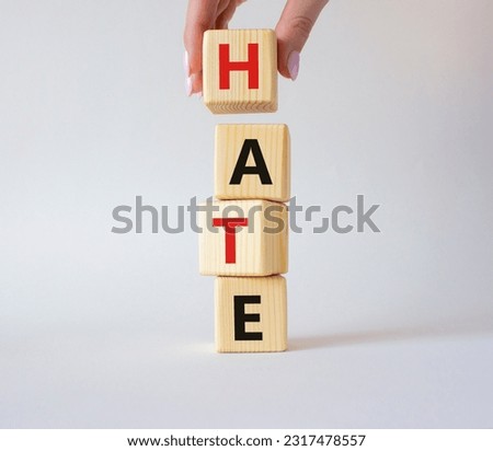 Hate symbol. Concept word Hate on wooden cubes. Businessman hand. Beautiful white background. Business and Hate concept. Copy space.
