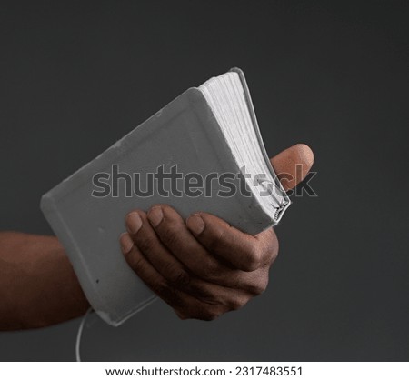 praying to God with hand on bible with black background with people stock photo