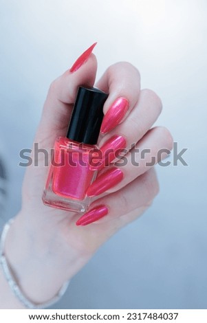 beautiful female hands with long nails and bright neon pink and red nail polish