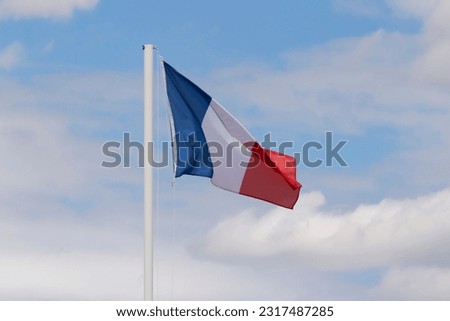 flag of France on flagpole against cloudy sky