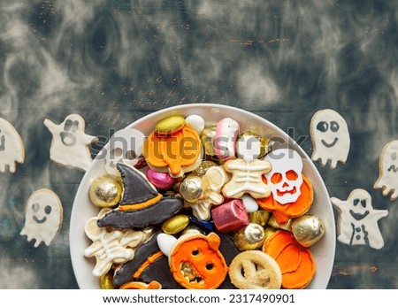 candy bowl with Halloween treats homemade thematic spooky cookies and candy sweets. Happy Halloween Jack o Lantern and  Trick or Treat