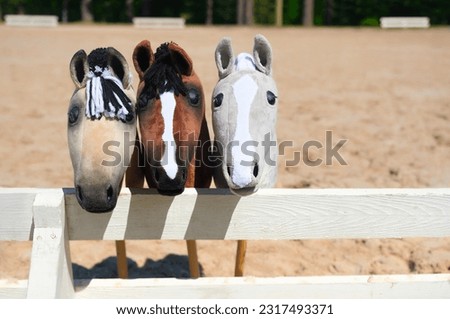 Three hobby horses are waiting for the riders. Equestrian sports. Equestrian equipment. Sports. Summer. The sun. Banner. Outdoors. Close-up Royalty-Free Stock Photo #2317493371