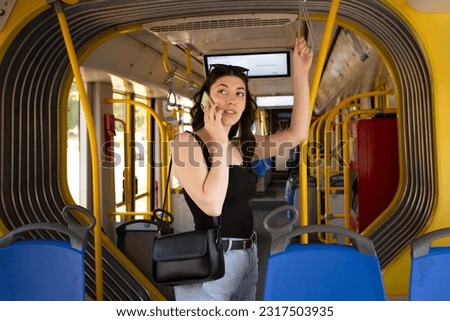 the girl in the tram is talking on the phone Royalty-Free Stock Photo #2317503935